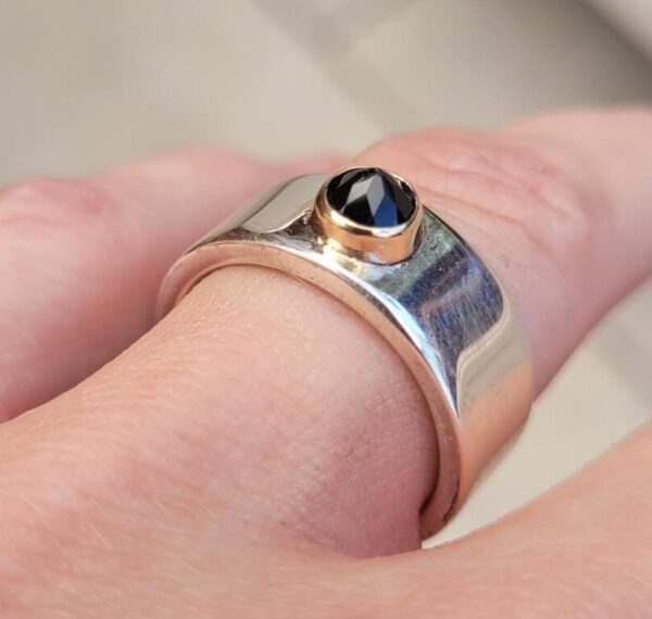 Silver ring with a reverse-set black spinel in a yellow gold setting