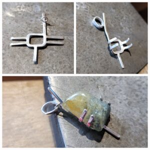 Rough sapphire in prong setting pendant.