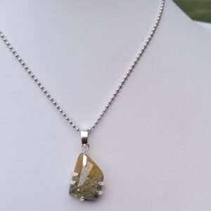 Rough sapphire in prong setting pendant.