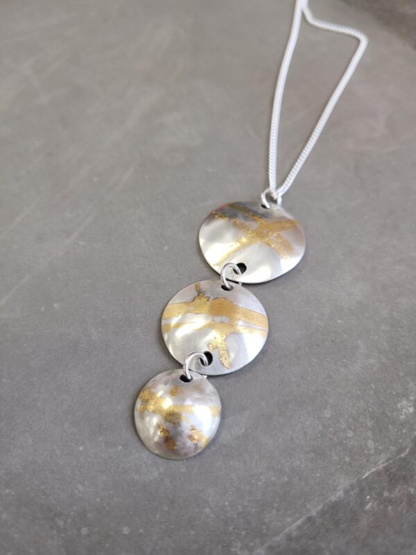 Silver pendants with a gold leaf element.