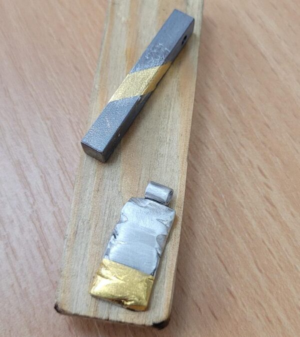 Silver pendants with a gold leaf element.