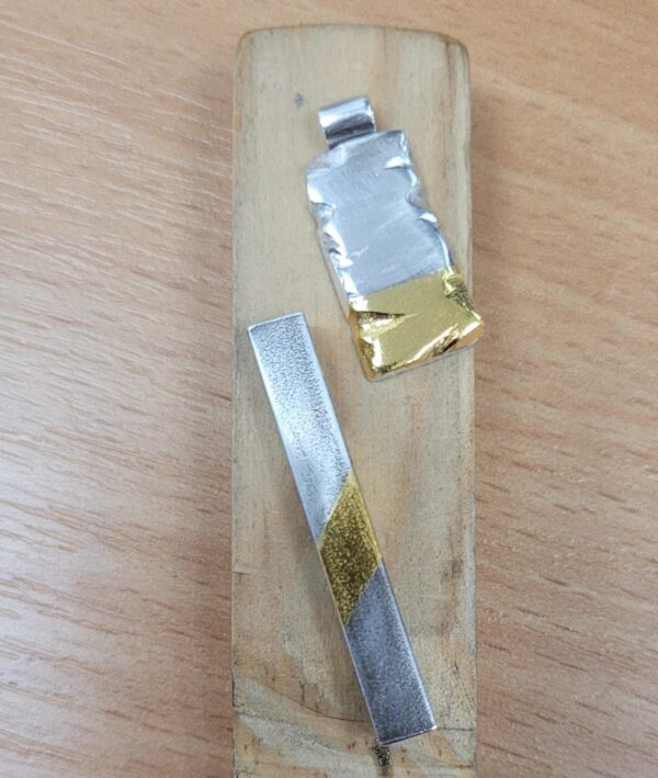 Silver pendants with a gold leaf element.