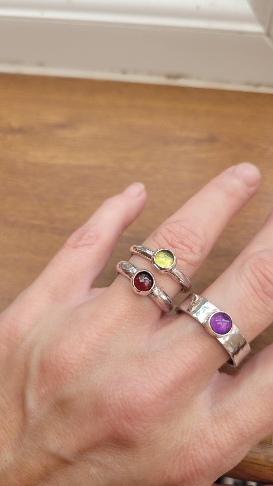 Silver rings set with garnet, amethyst and peridot cabochons.