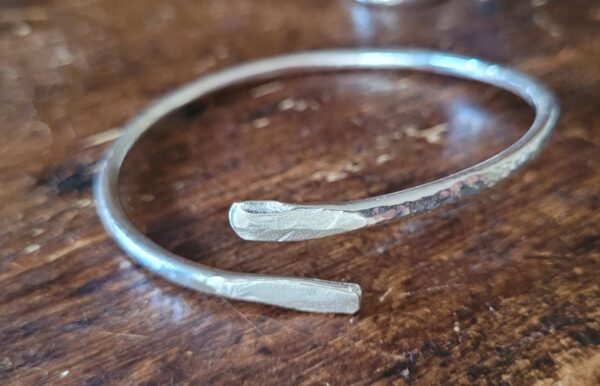 Silver cuff bangle with wrap design.