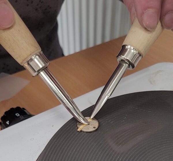 Applying gold leaf to silver as part of the technique named Keum Boo.