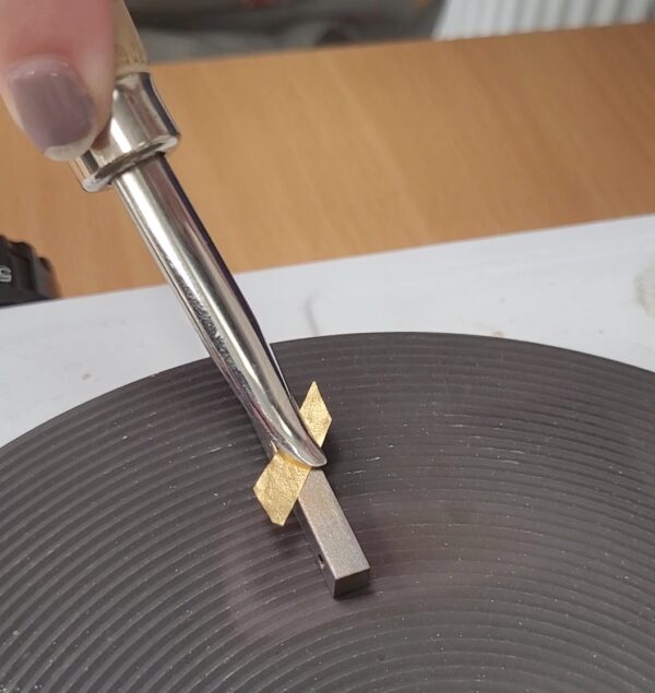 Applying gold leaf to silver as part of the technique named Keum Boo.